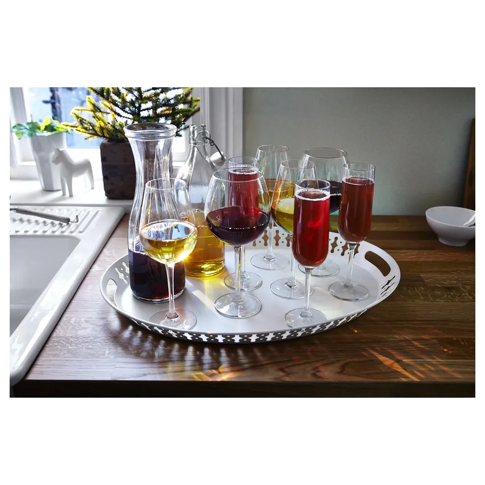 White tray with varied wine glasses, two carafes, on wooden table by window. Decorative and practical for serving drinks.