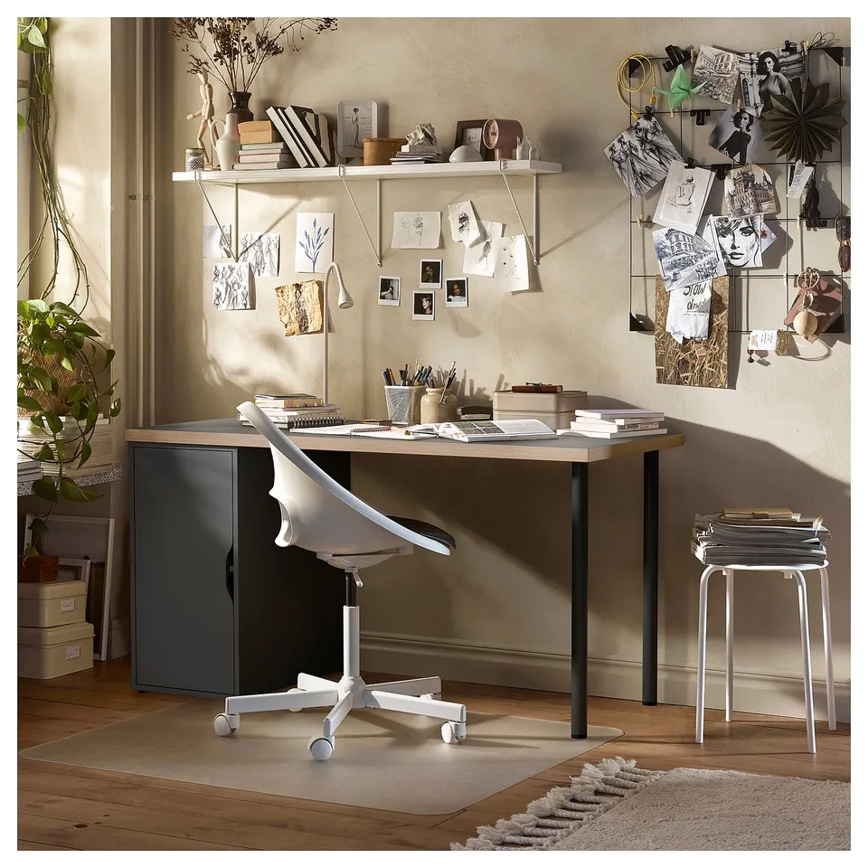 Desk setup with LAGKAPTEN table, white chair, grey storage unit, wooden floor, and wall decorations.
