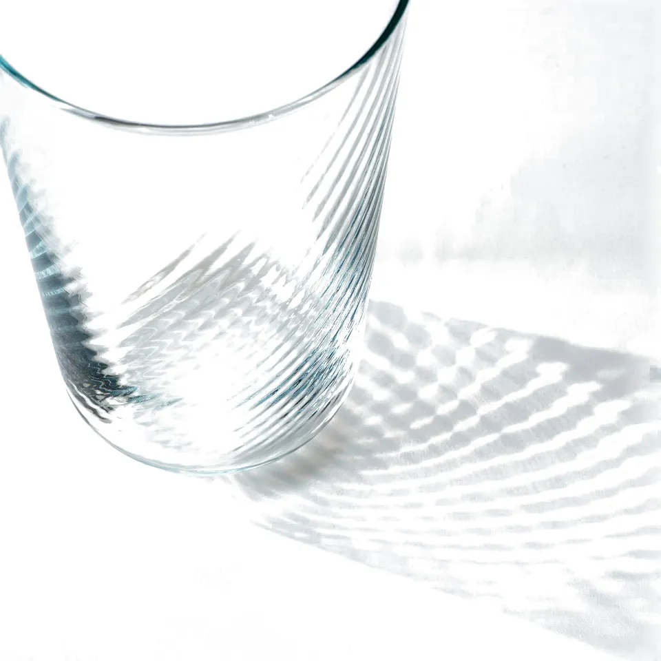 Elegant, thin glassware with a smooth exterior and tactile rippled interior, reflecting light beautifully.