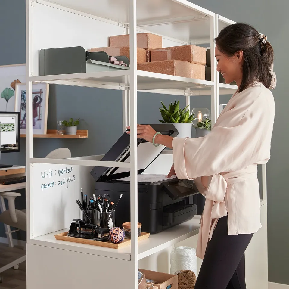Person interacts with TROTTEN cabinet, lockable doors, open shelves, and sound absorption.