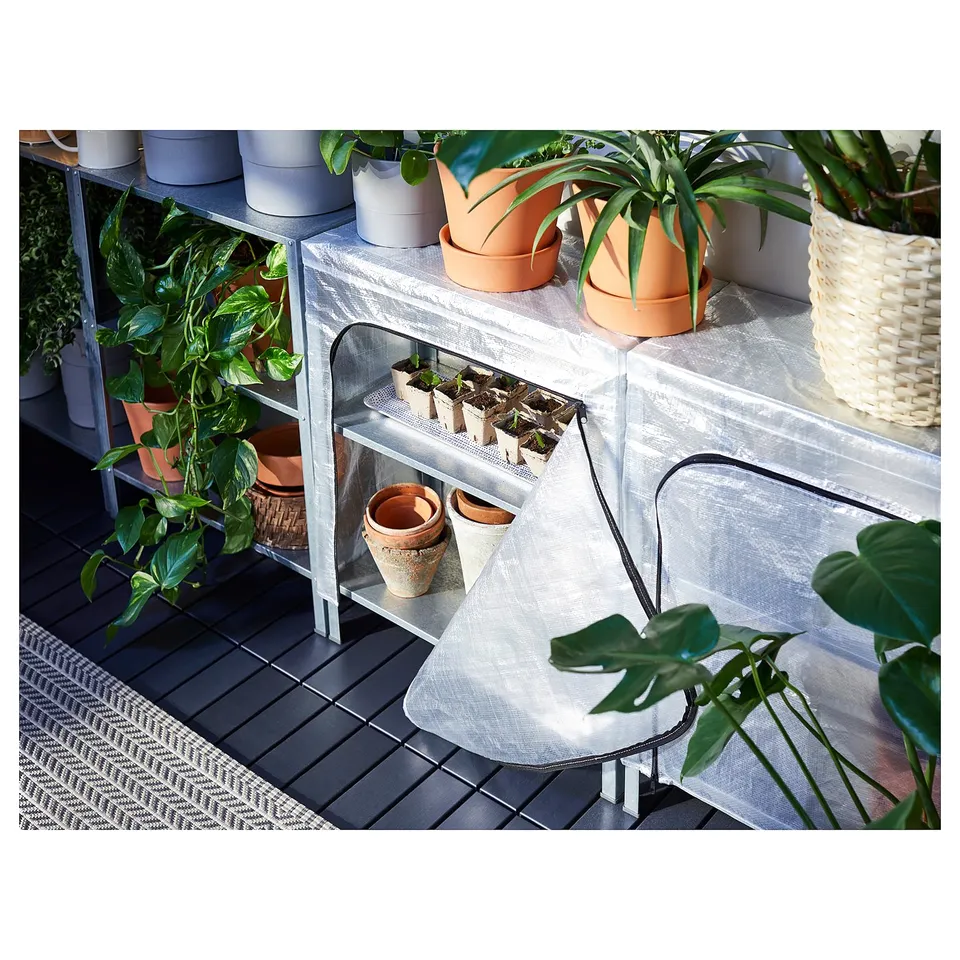 Small greenhouse with various potted plants on grey shelves. Cover has mesh sides for air circulation.