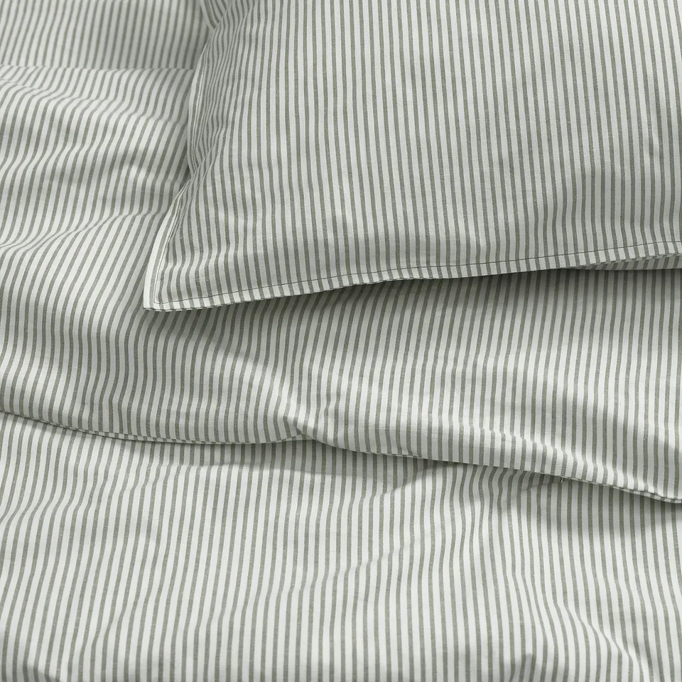 Stacked striped bed sheets, neatly folded, displaying high-quality cotton texture.