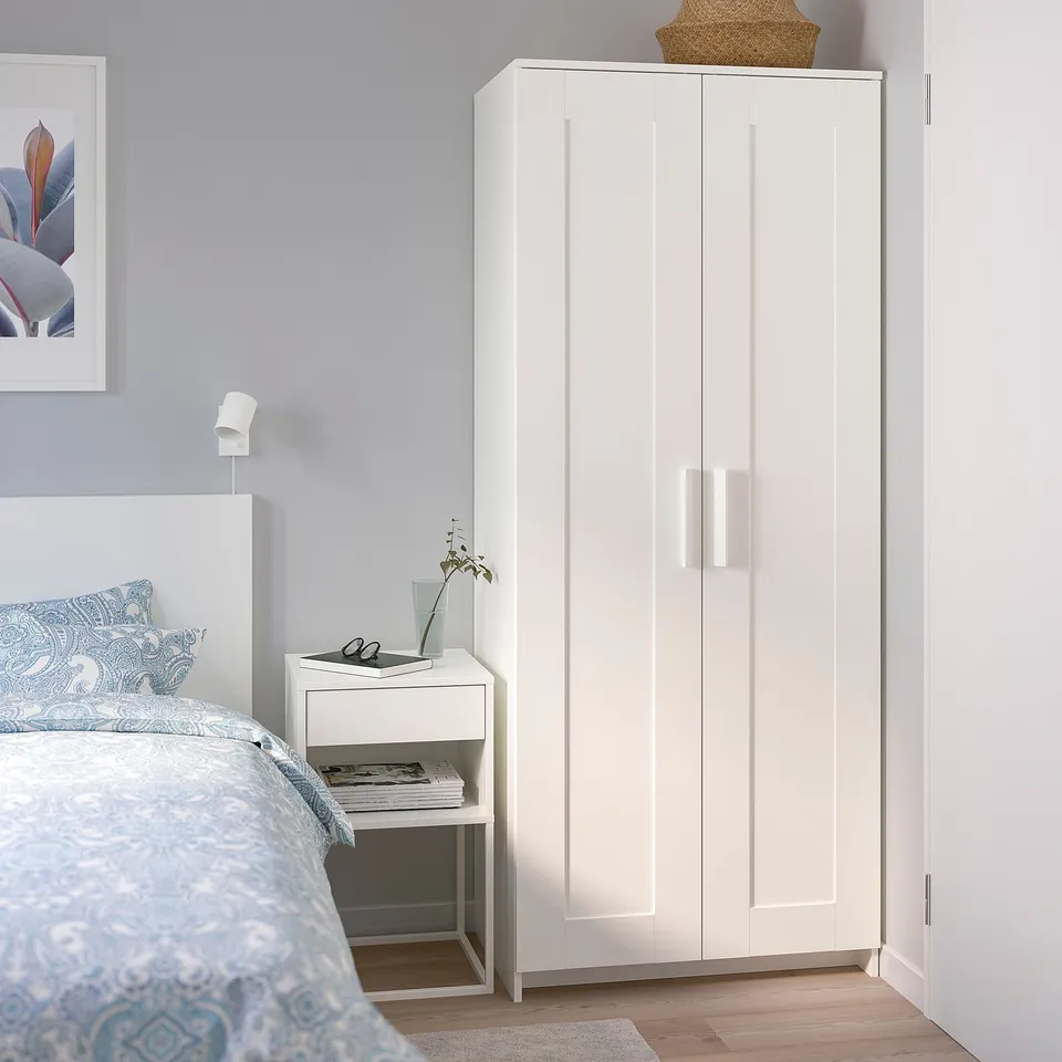 White BRIMNES wardrobe in bedroom, offers storage, blends with decor.