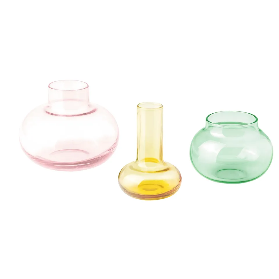 Three colourful glass vases in pink, yellow, and green, each with a unique shape, arranged in a row.