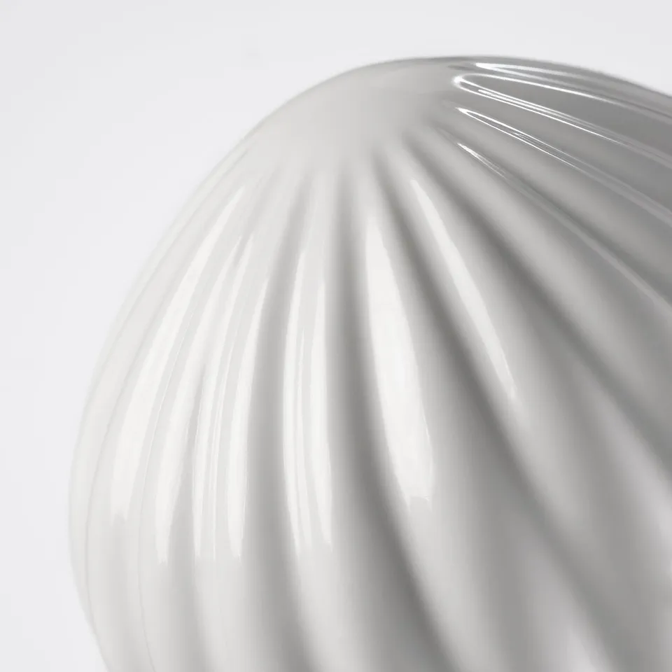 Ceramic finial close-up, showcasing smooth, glossy texture and elegant ribbed design.
