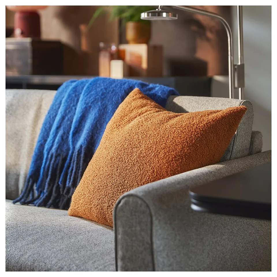 Cushion on chair, brown-red colour, soft teddy-like texture.