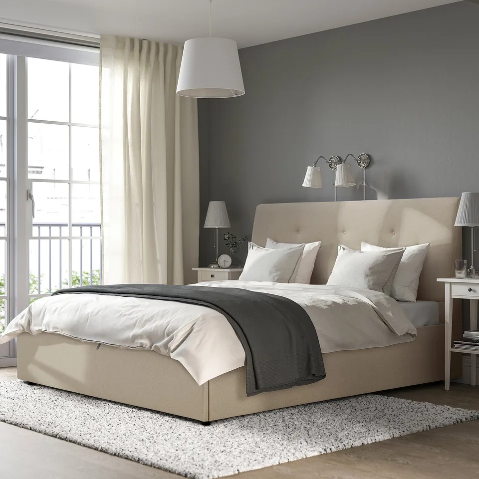 Beige IDANÄS upholstered bed with large headboard and grey/white bedding.