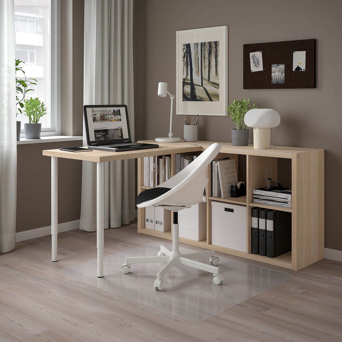 Modern home office with KALLAX storage, adjustable desk, laptop, bookcase, ergonomic chair, plants, minimalist decor.