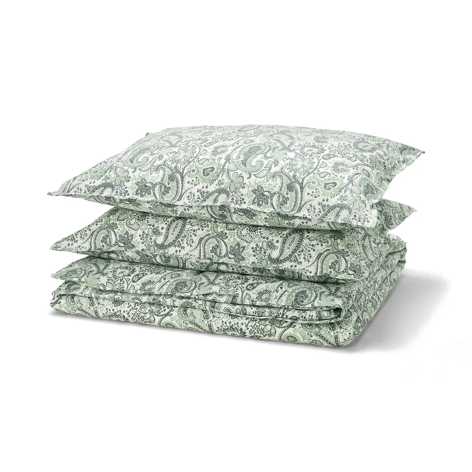 Green paisley patterned bedding set, featuring intricate designs on cotton-viscose blend fabric, neatly folded and stacked.