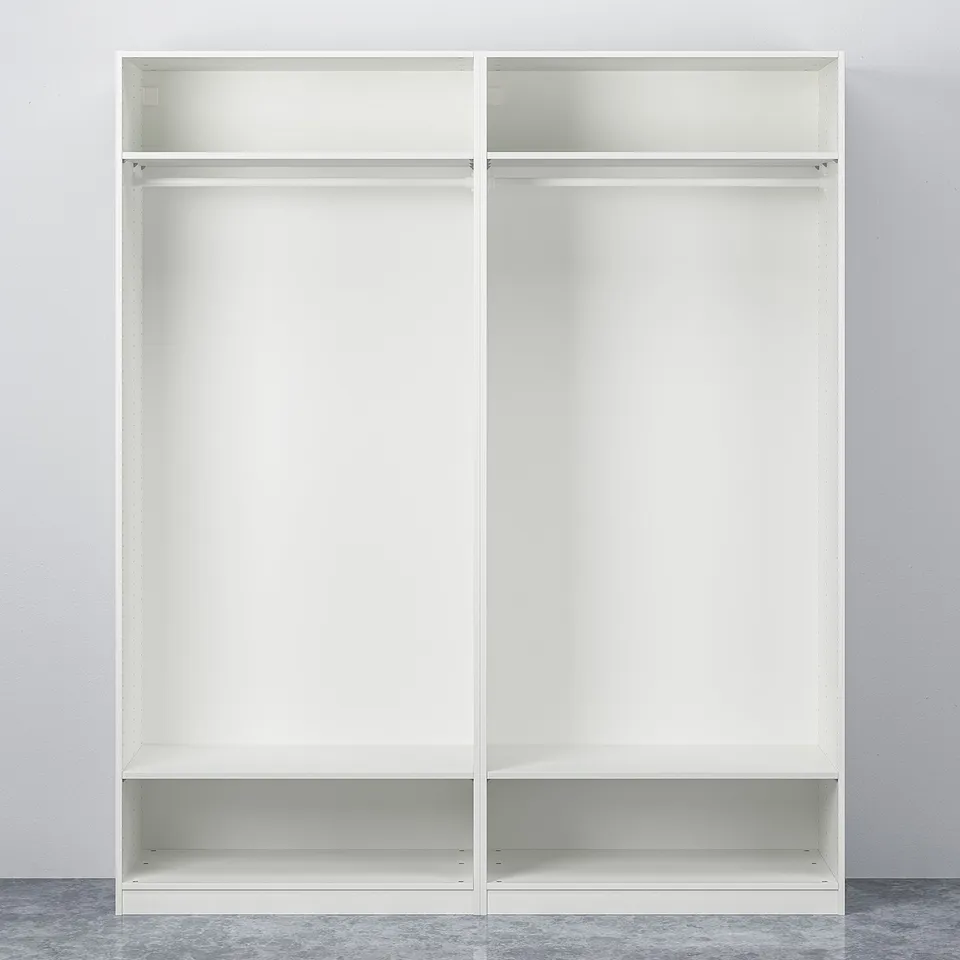 Two white PAX wardrobes with open, empty shelves and hanging rails against a plain wall.