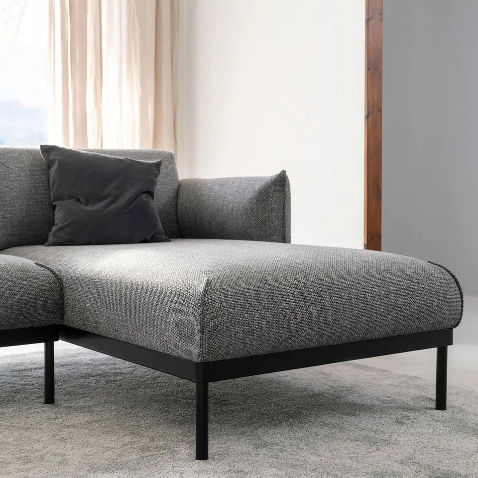 Modern grey fabric sectional sofa with black metal legs, perfect for relaxing.