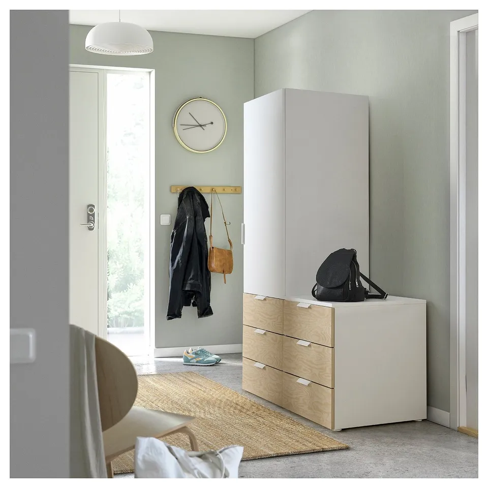 Modern entryway with PLATSA storage, backpack, coat hooks, and clock.