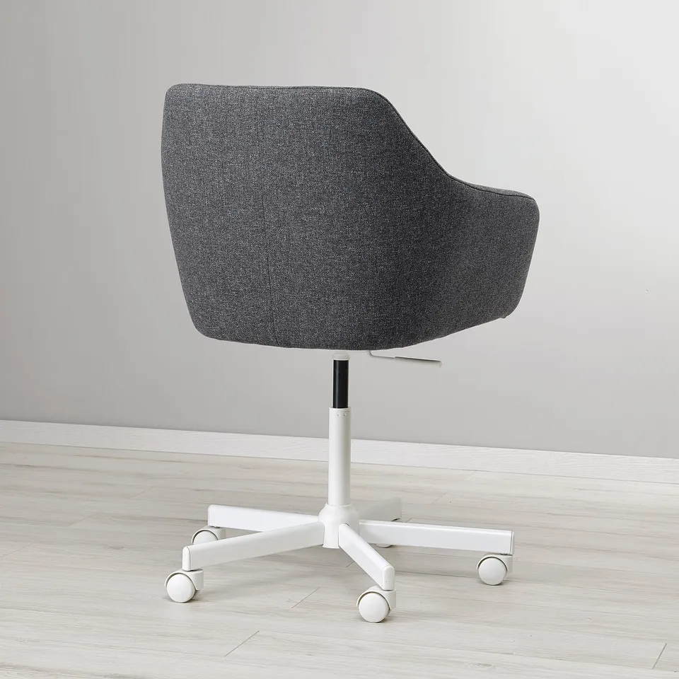 Modern office chair with dark grey upholstery, ergonomic design, and adjustable height, on castors for easy movement.