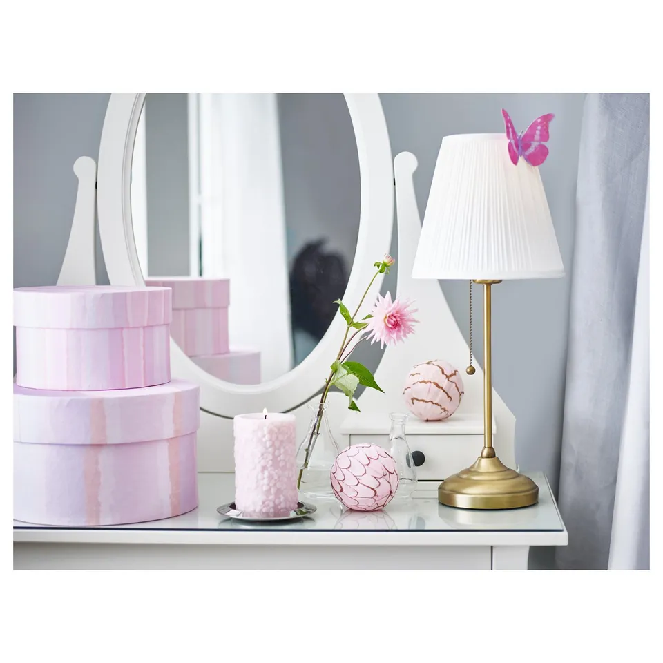Stylish ÅRSTID lamp with white shade on table, surrounded by decor.