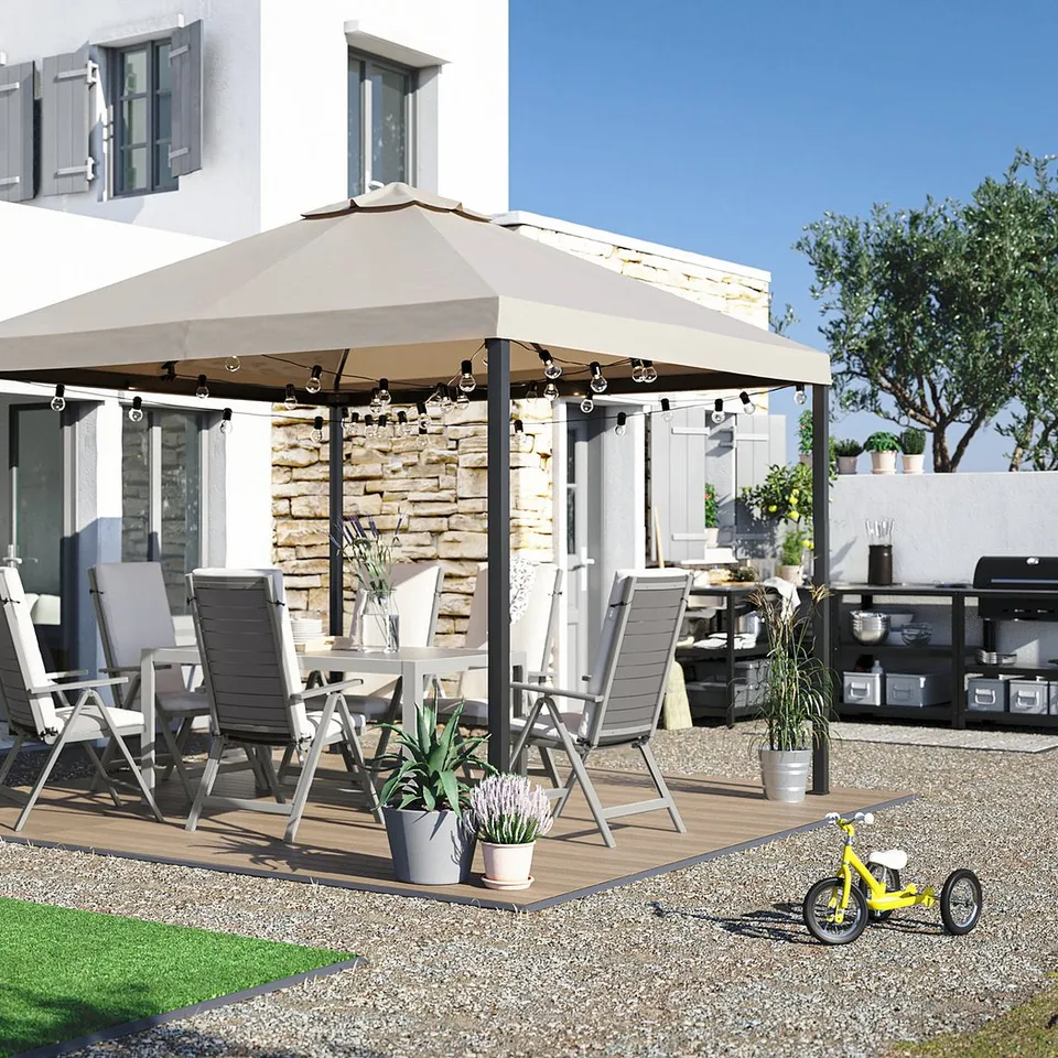 Cosy backyard patio with beige umbrella, grey chairs, wooden table, plants, and a yellow kids bike on pebbles.