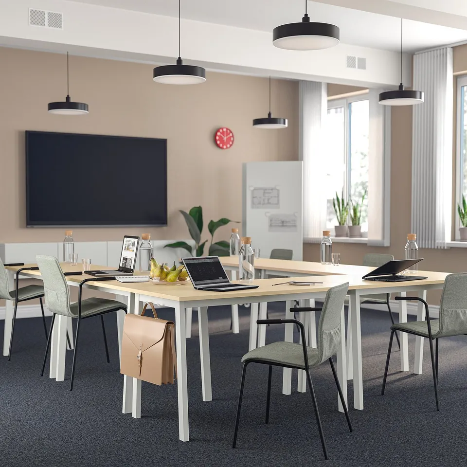 Modern office with MITTZON tables, chairs, & red clock - u-shape setup for meetings.
