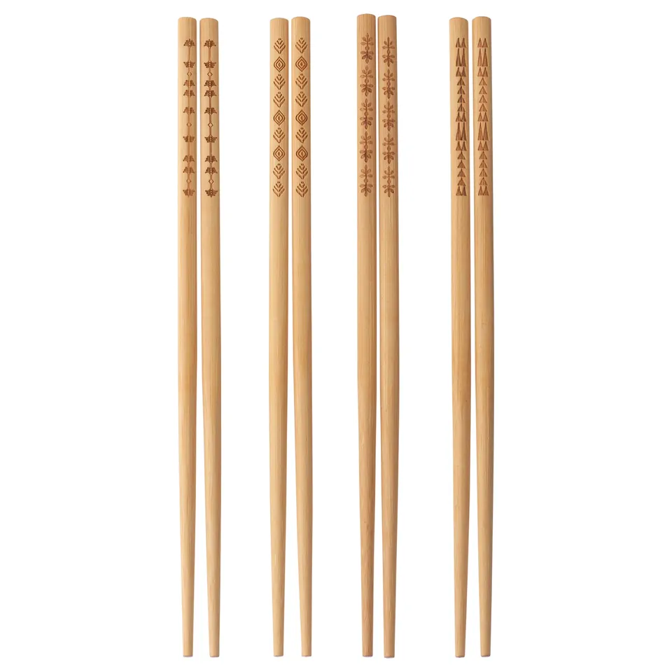 Set of decorative bamboo chopsticks in light beige with etched patterns.