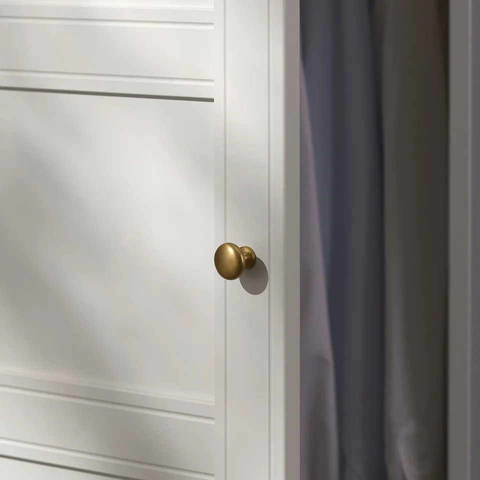 A white cabinet door with a golden doorknob, sleek design, modern finish.