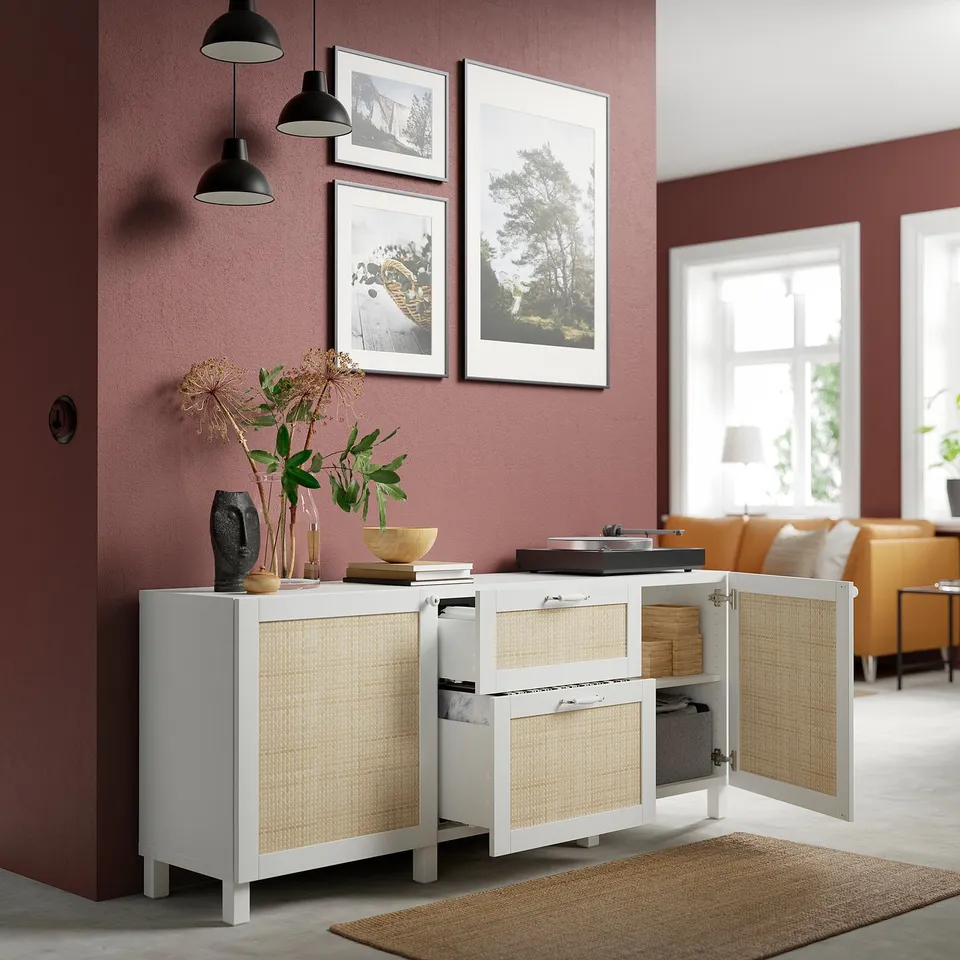 White sideboard with cane doors and drawers, displaying decor items, with storage shelves behind doors and drawers.