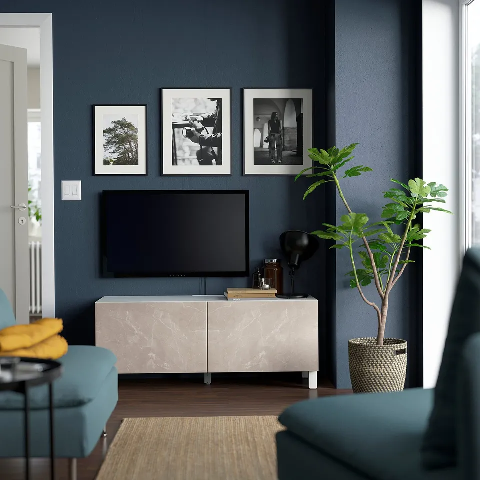 Modern living room with BESTÅ tv stand, blue wall, green chair. Marble-like tv bench with storage and cable management.
