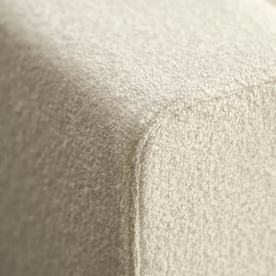 Close-up of soft, textured beige sofa fabric, showcasing high-quality stitching and plush material.