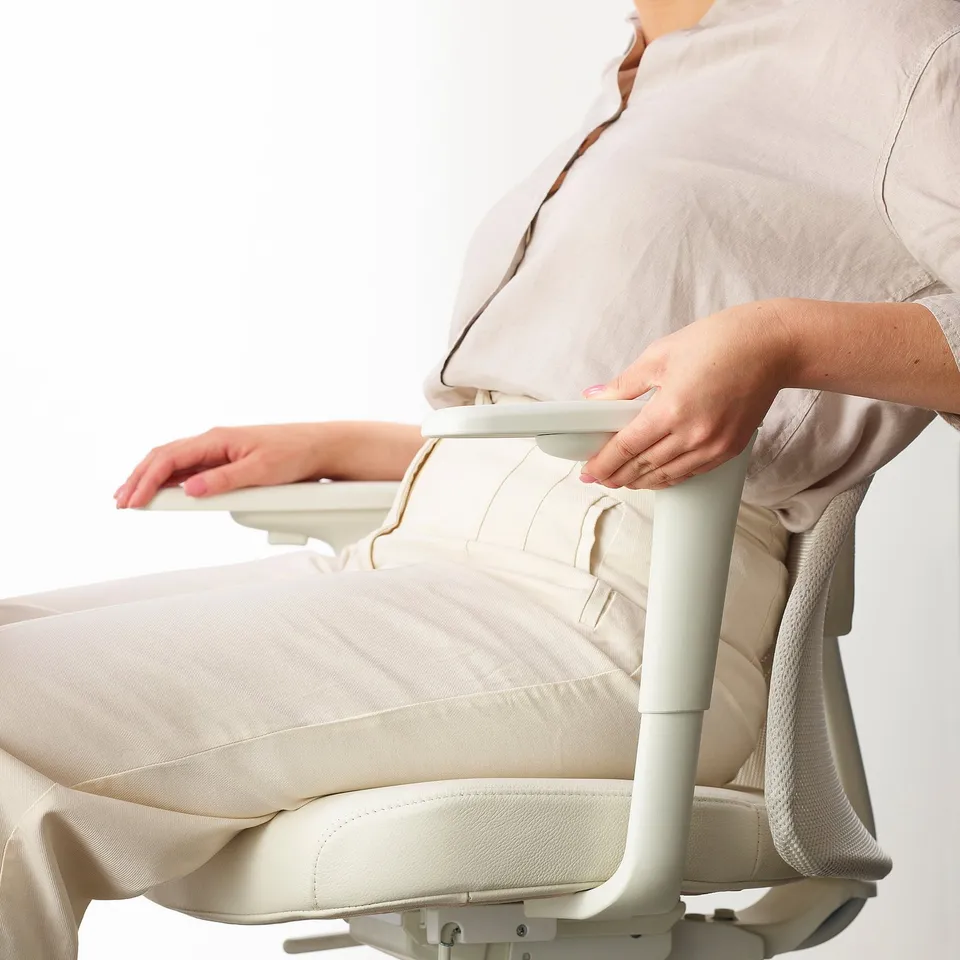 Person adjusting lumbar support on ergonomic office chair, ensuring comfort and back support.