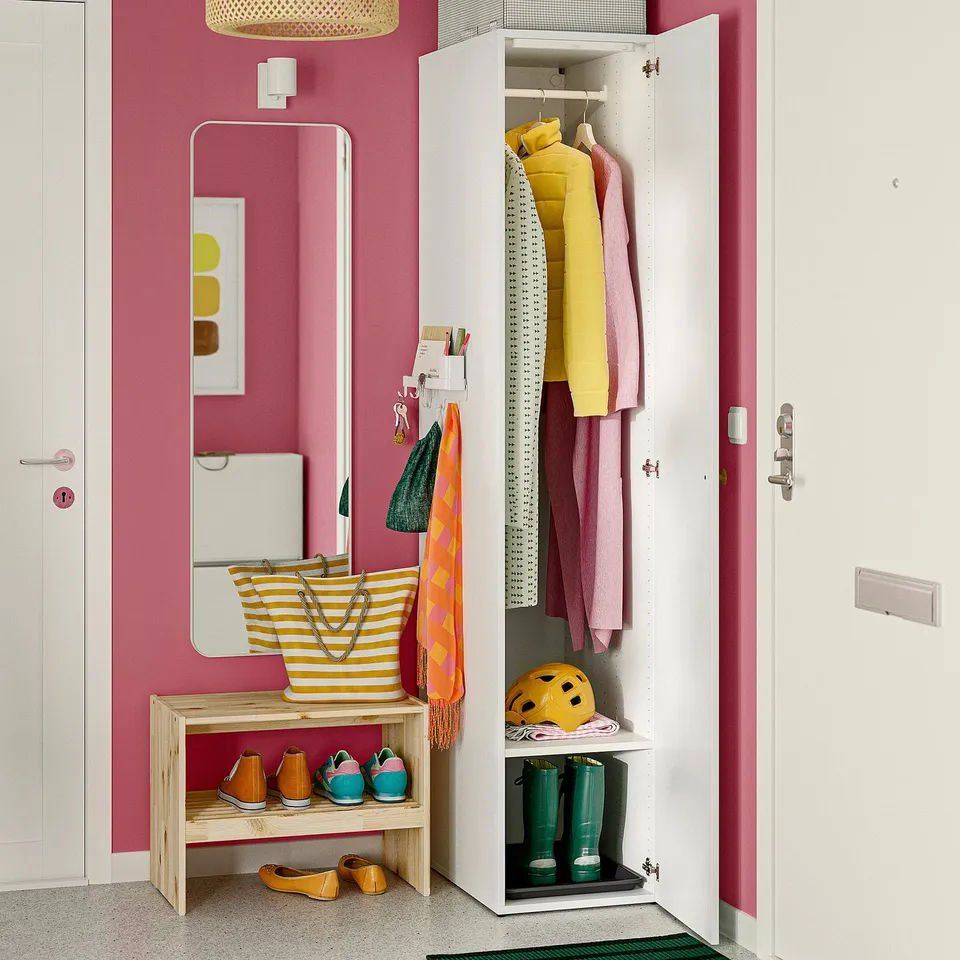 Pink entryway with jackets, striped bench, orange towel.