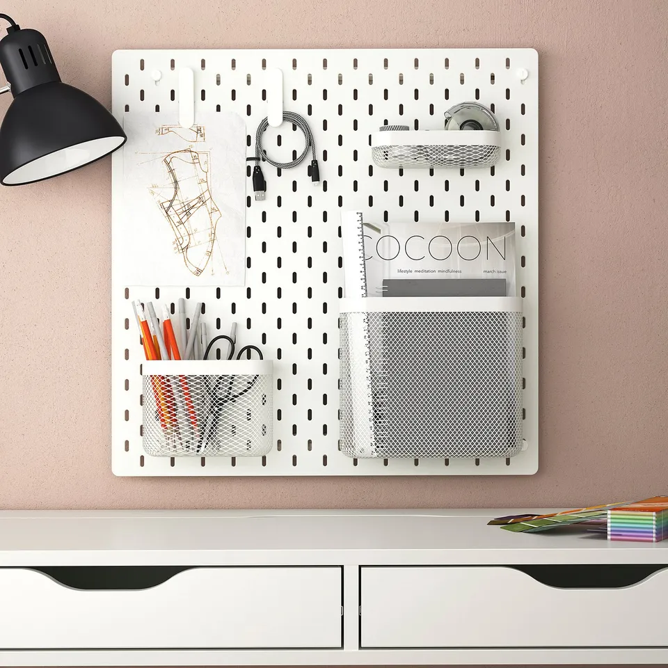 SKÅDIS pegboard with accessories on wall above desk, lamp nearby
