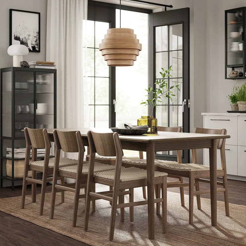 Modern 4-seat dining set with extendable table, woven chairs, glass cabinet, plants, and yellow vase.