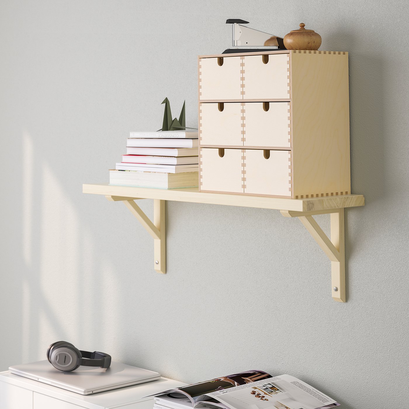 Wall-mounted shelf with drawers and brackets, displaying books and decor.