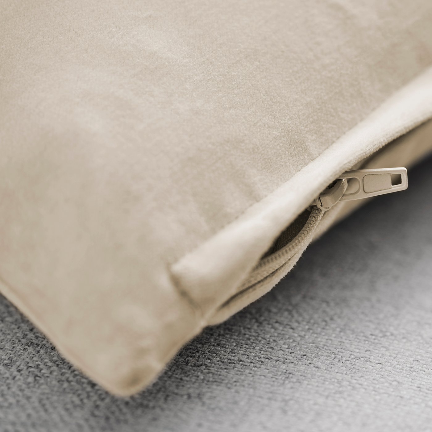 Close-up of a velvet cushion cover with a zipped opening, showcasing its smooth texture and quality.