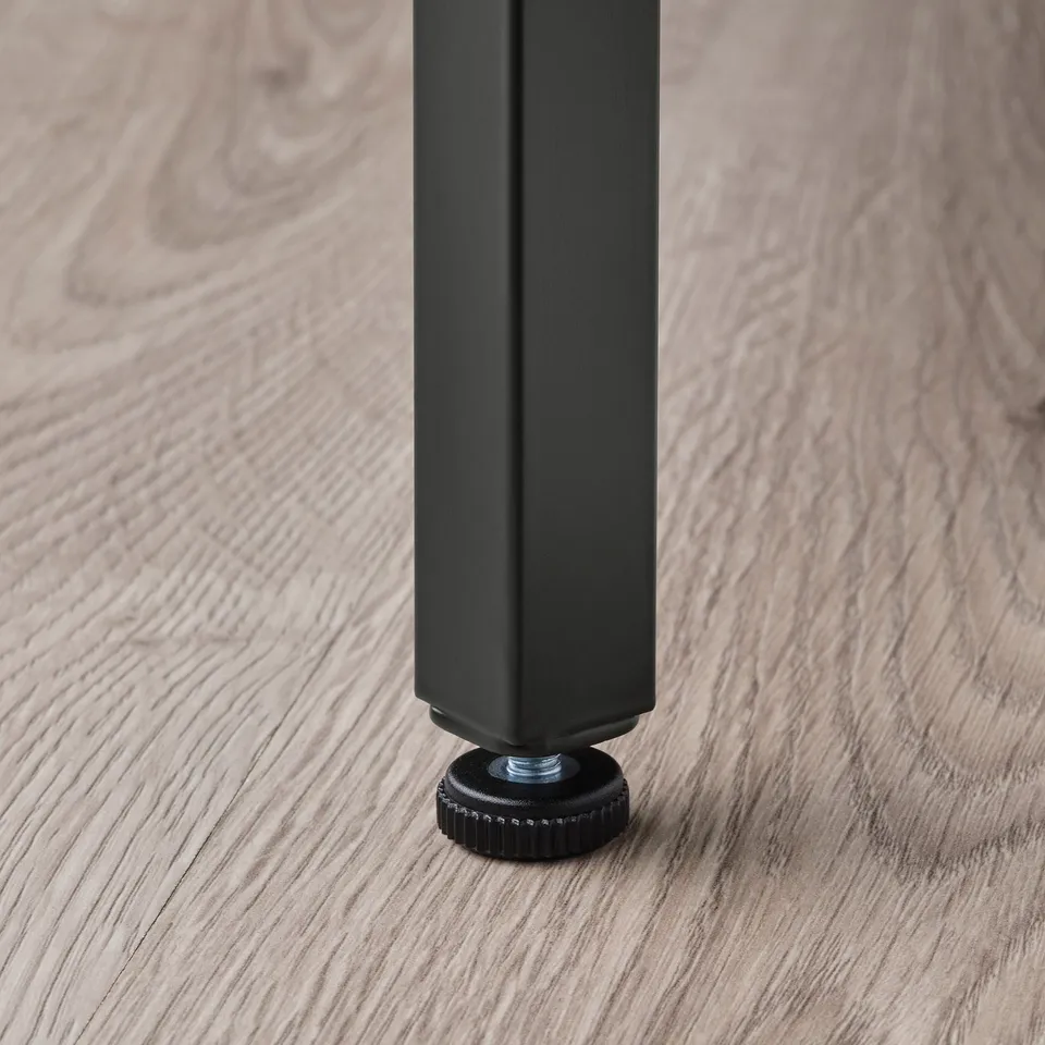 Close-up of VITTSJÖ table leg with adjustable foot.