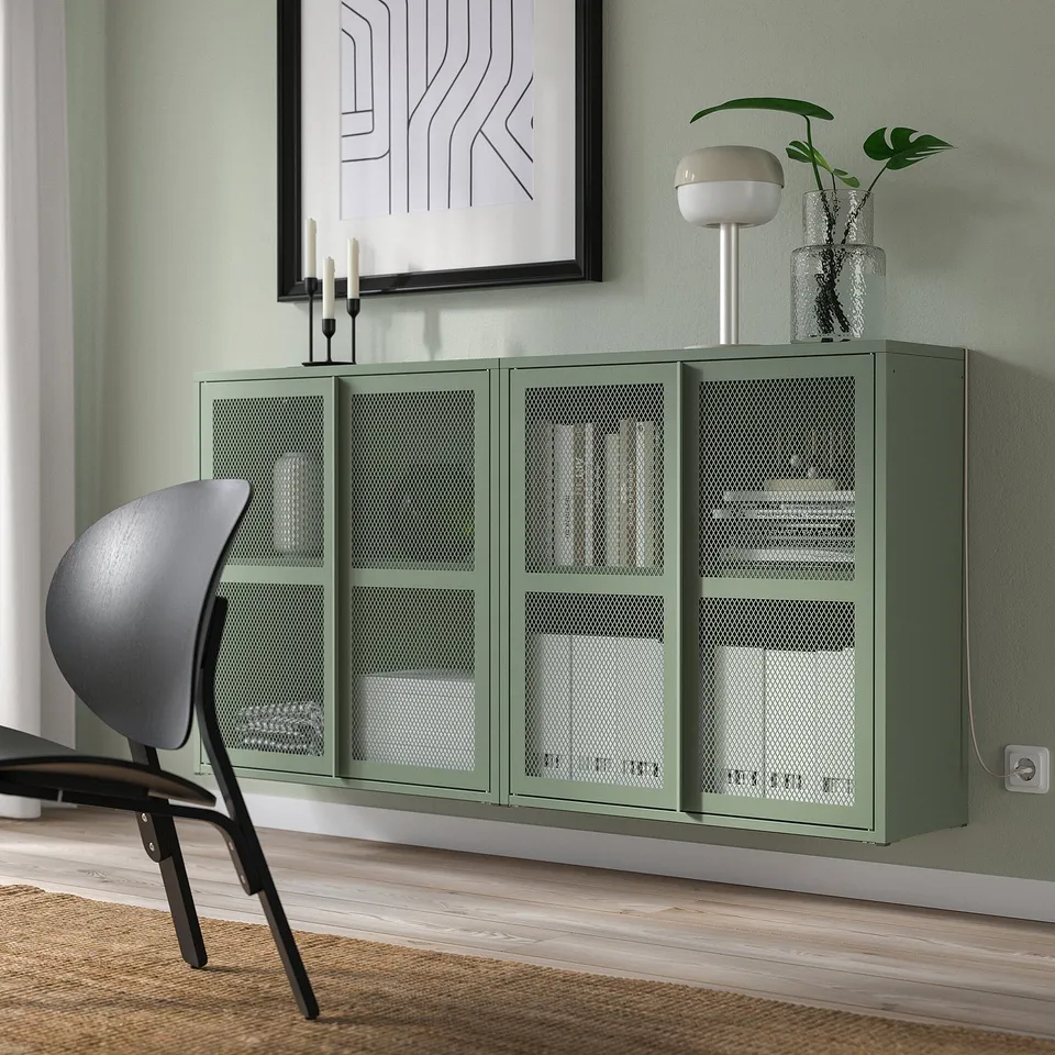 Modern living space with green IVAR cabinet, books, plants & chair.
