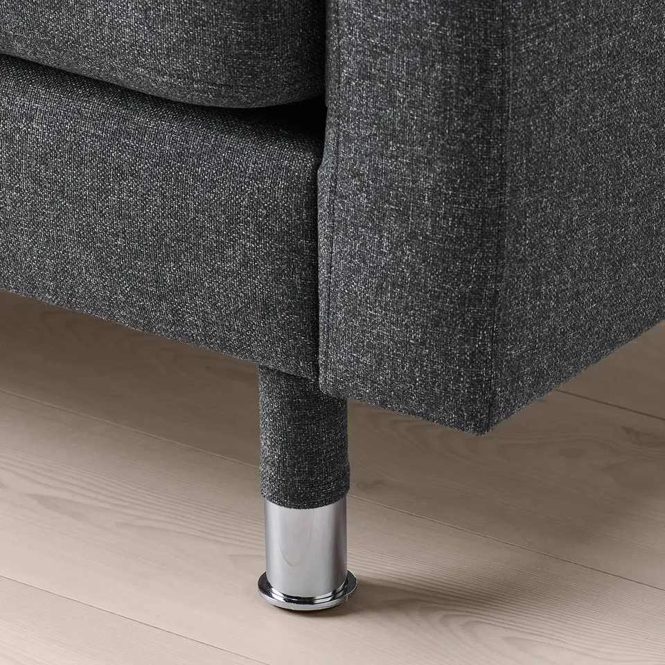 Closeup of modern sofa leg, chrome finish, sturdy design.