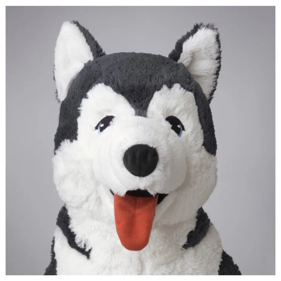 Soft plush husky toy with bright blue eyes, sticking out tongue, black and white fur, inviting and well-made.