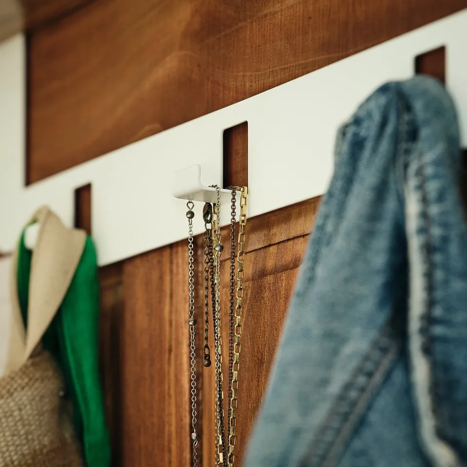Wooden door with hooks holding chains and jackets, showcasing quality hanging system.