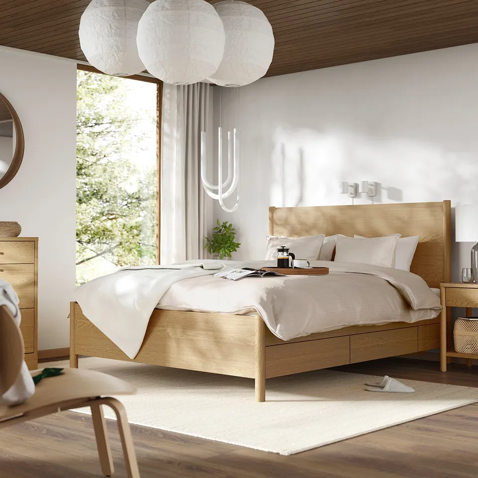 Modern bed, pendant lamps, chair, and chest in cosy room