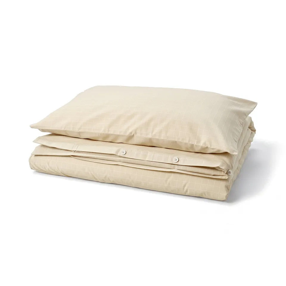Beige/white stitched check duvet cover, folded with corner pockets, made of 100% cotton.