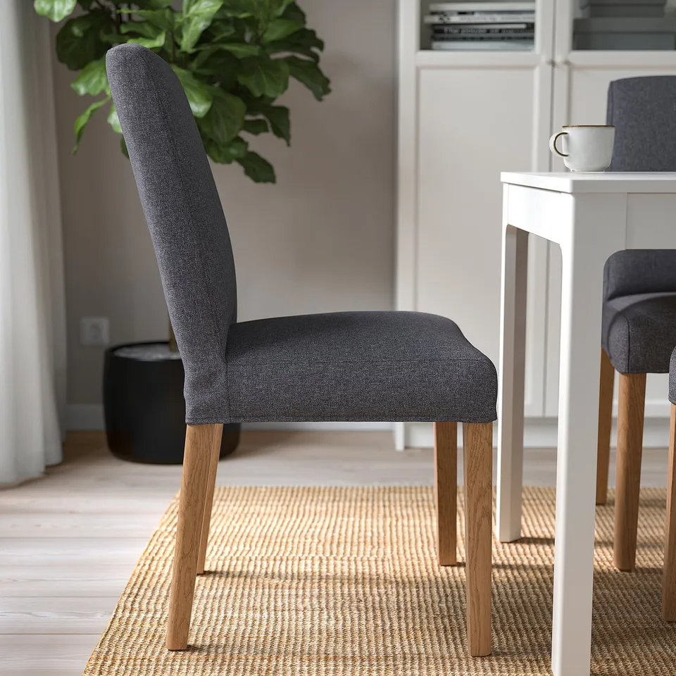 Modern upholstered chair with wooden legs, designed for comfort and easy cleaning. Grey fabric cover, excellent for dining.