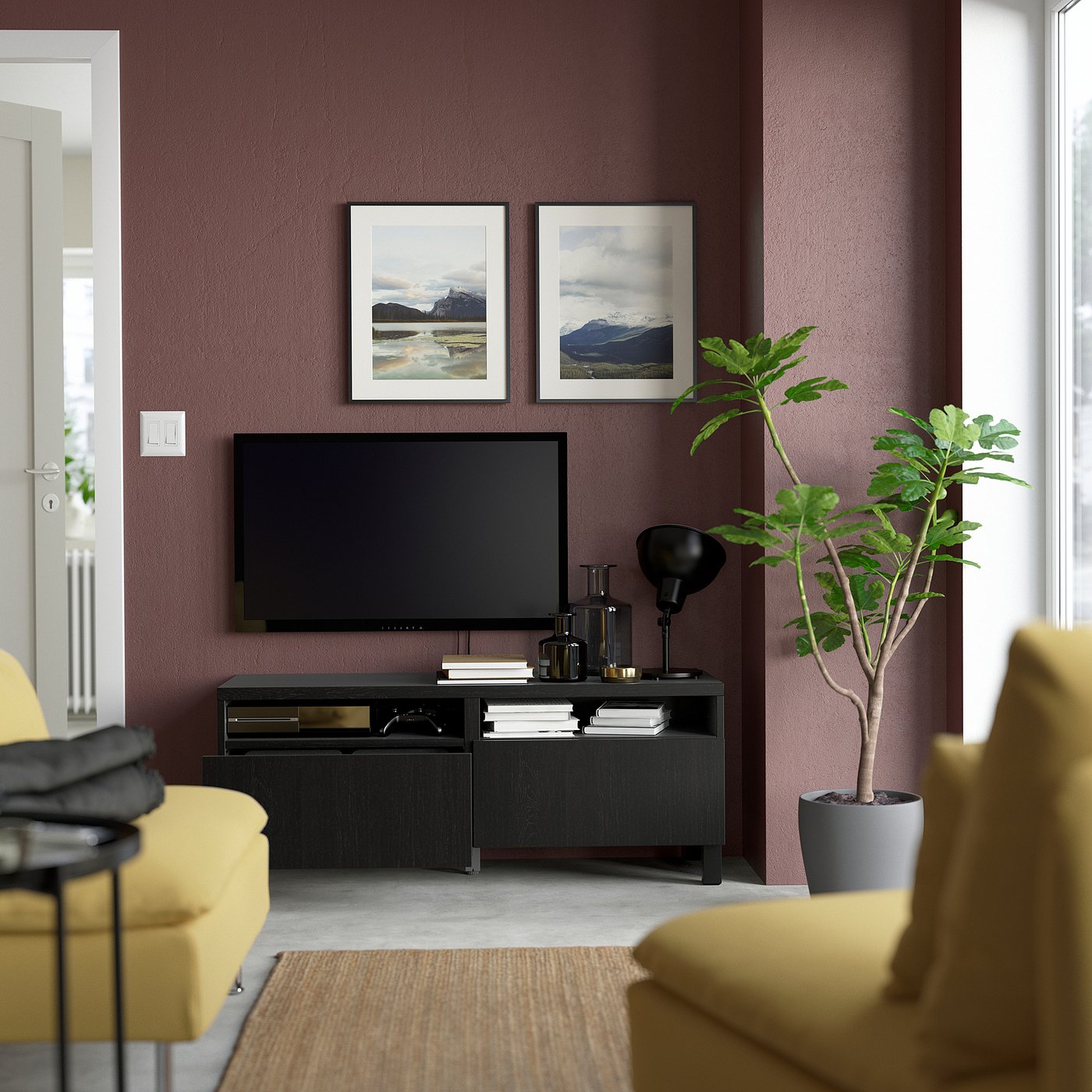 Living room with purple walls, nature photos, tv stand with drawers, green plant, yellow armchairs.