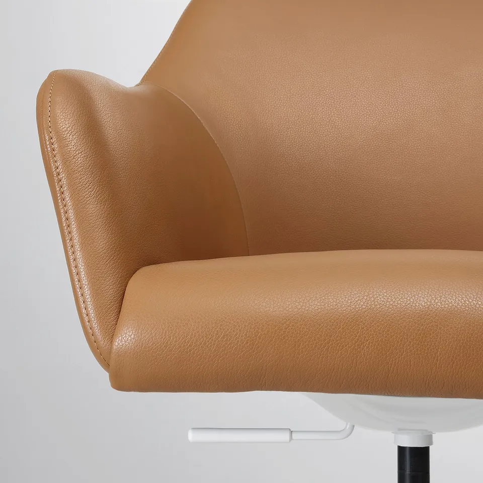 Close-up of a smooth, upholstered chair armrest in tan leather, showcasing high-quality stitching and comfortable padding.