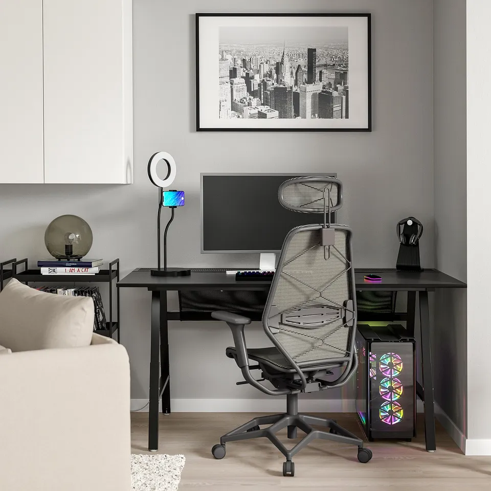 Minimalist home office: black desk, mesh chair, pc, monitor.