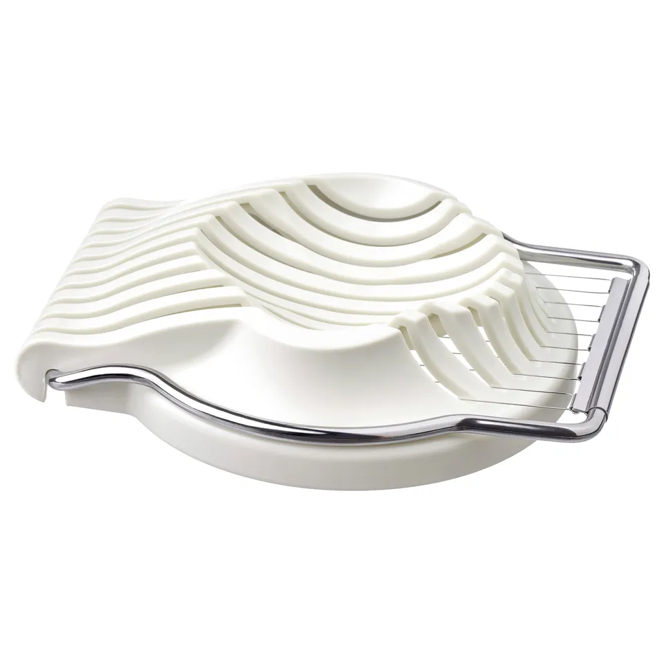White egg slicer, metallic handle, curved shape, textured grip.