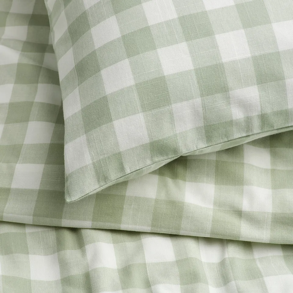 Green and white gingham duvet cover, neatly folded, showcasing soft, high-quality fabric with even check pattern and smooth stitching.