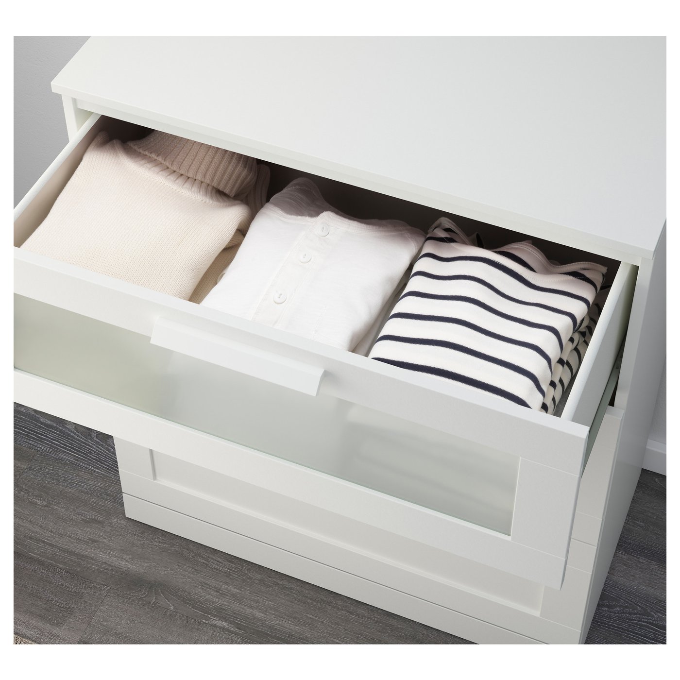 A white drawer unit with clothes. Folds neatly, ideal for small spaces.