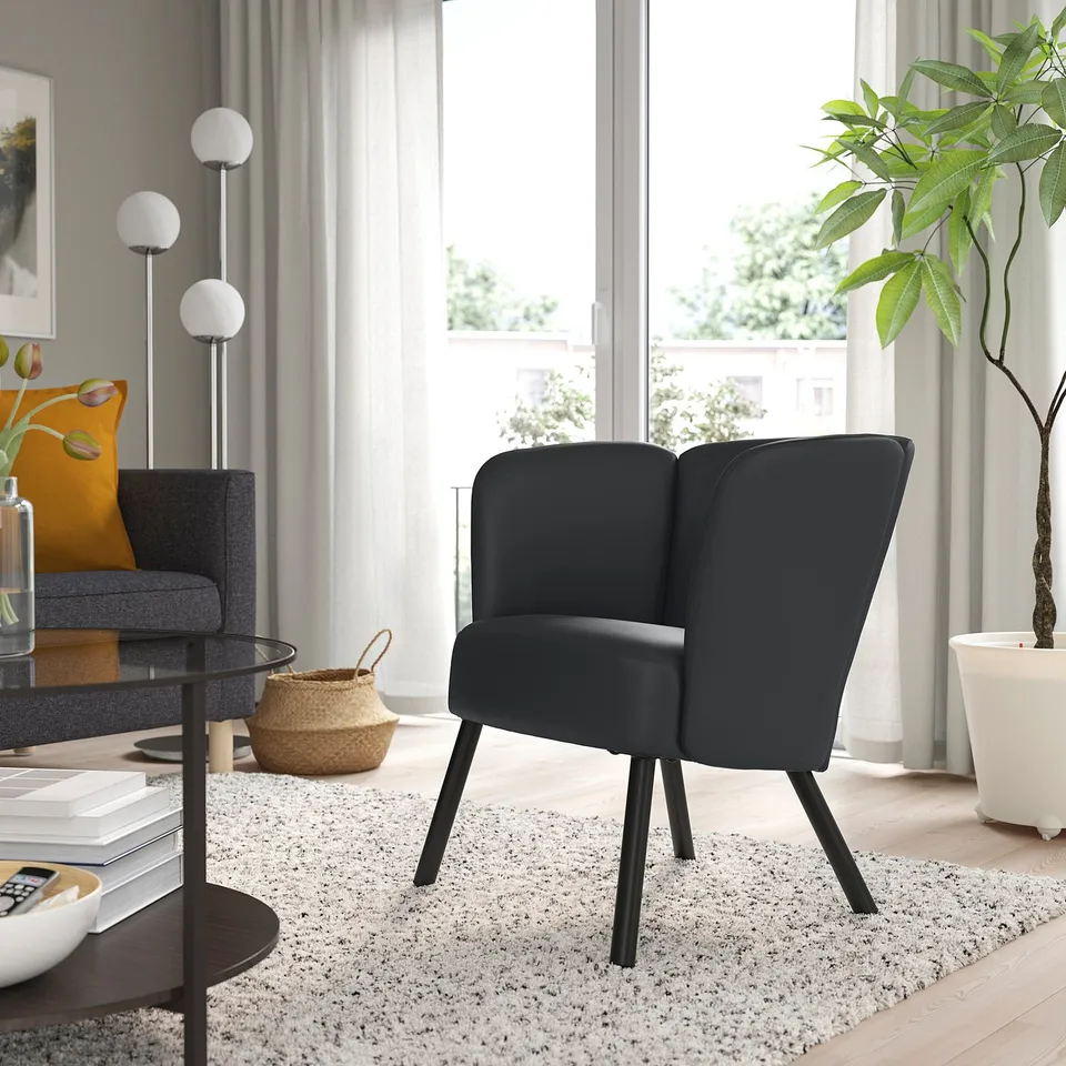 Black HERRÅKRA armchair in modern living room.