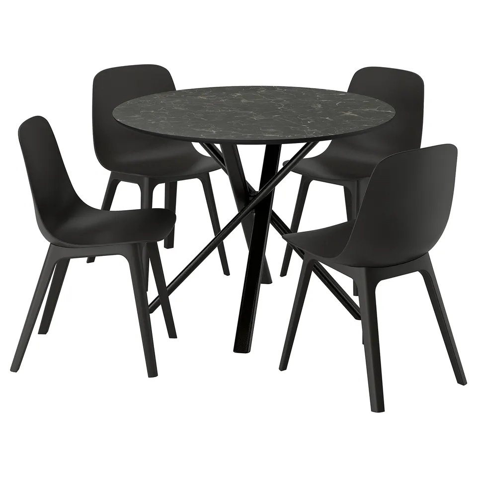 A norrmjölle black dining set including a round table and four black chairs with curved seats and metal legs.