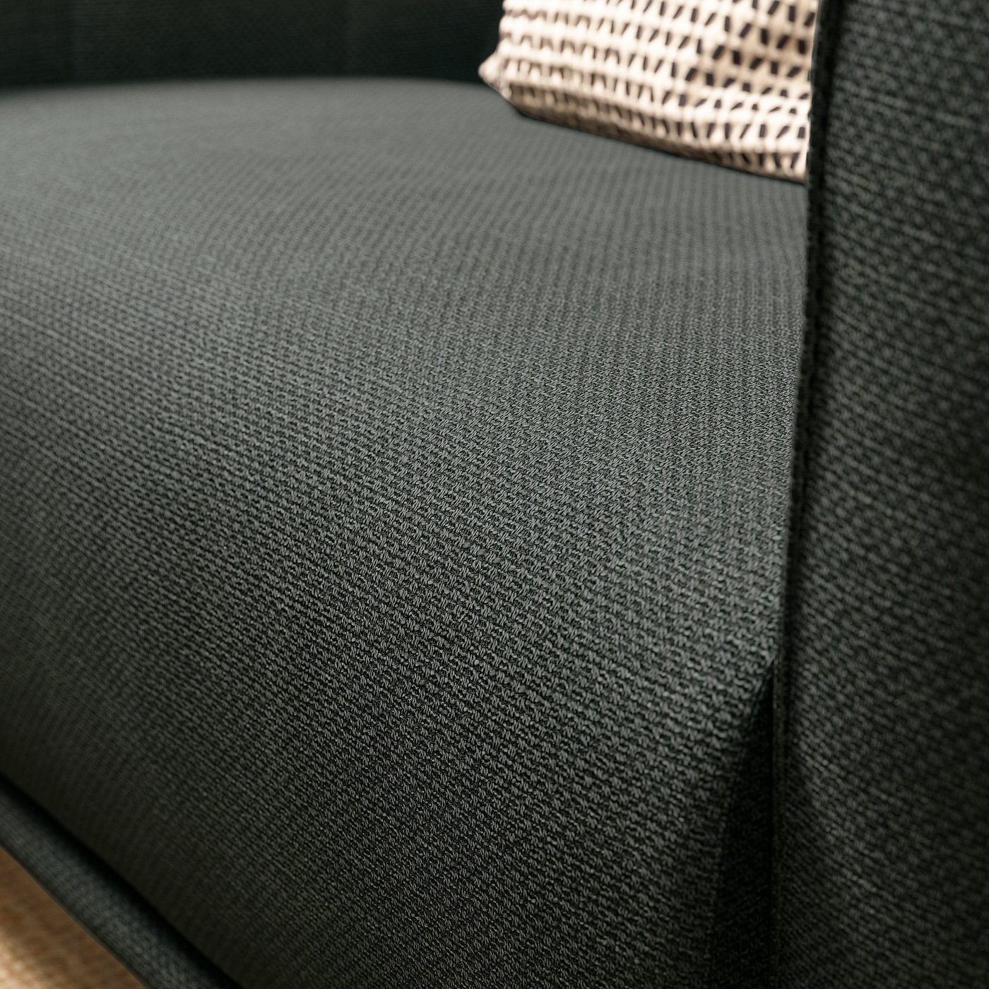 Dark grey VISKAFORS armchair close-up, soft fabric, curved shape.