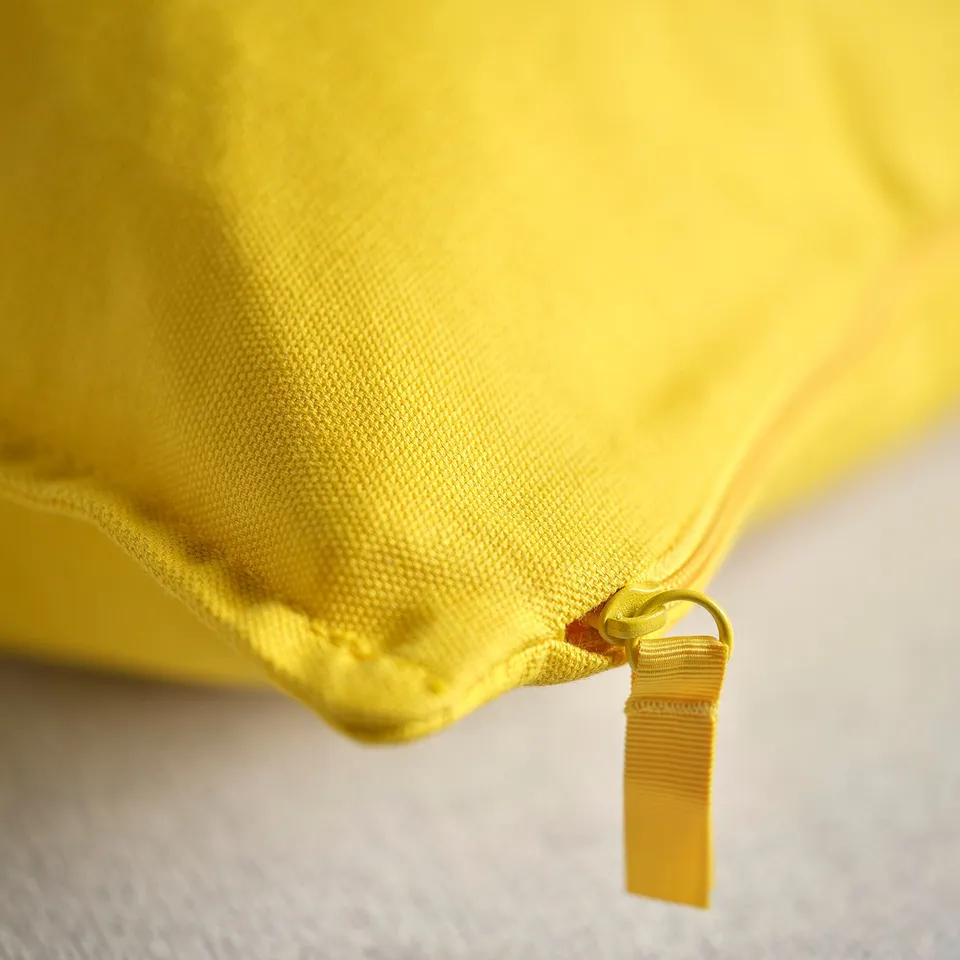 Bright yellow cushion cover with a durable zip, made from quality cotton, including recycled materials.