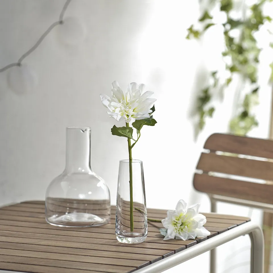 SMYCKA white dahlia in clear glass vase on wooden table.